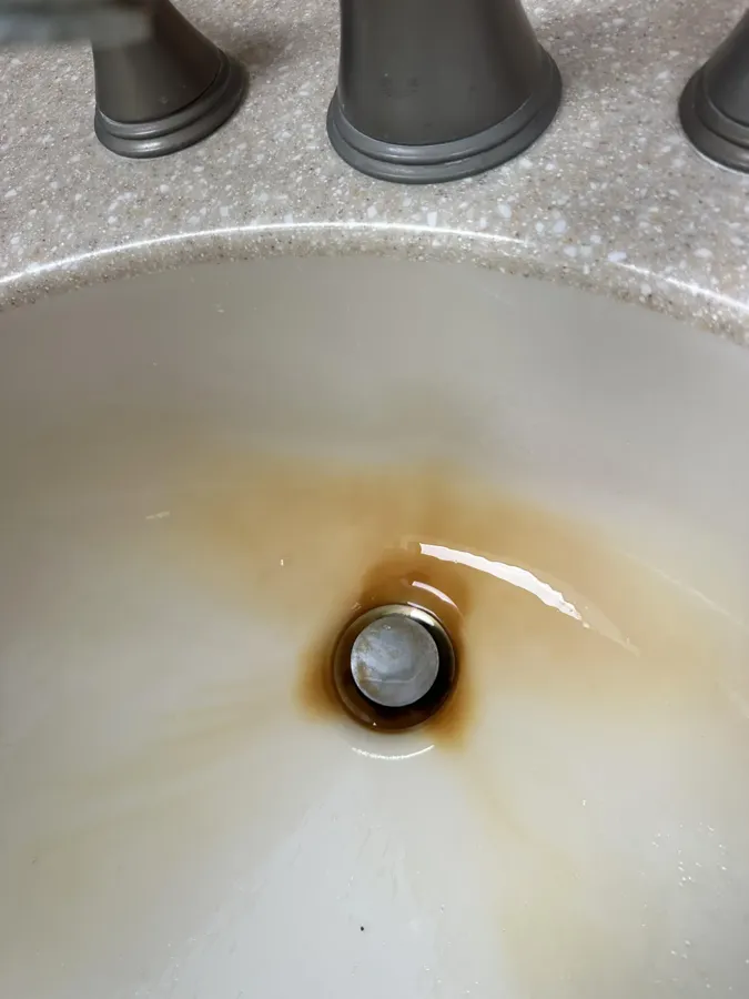 Bathroom sink and fixtures before cleaning