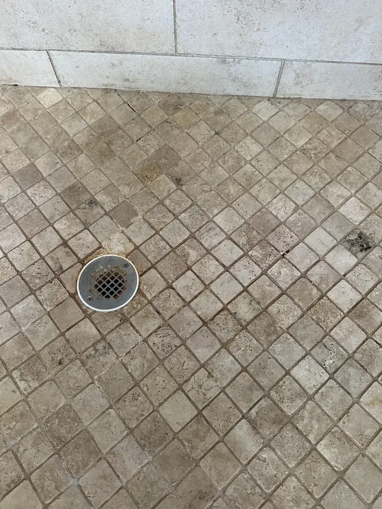 A tiled shower floor after a Happy Maids move clean, soap scum and hard water lifted