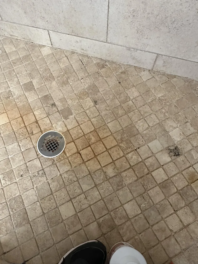 A shower floor before a Happy Maids visit