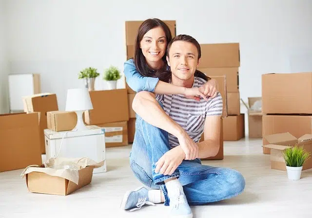 Couple surrounded by moving boxes.