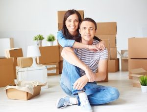 Couple surrounded by moving boxes.